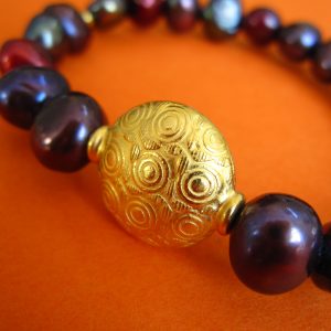 Dunkles Perlen Armband mit vergoldetem, rundem Ornament